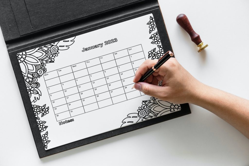 mockup of someone writing on a coloring calendar